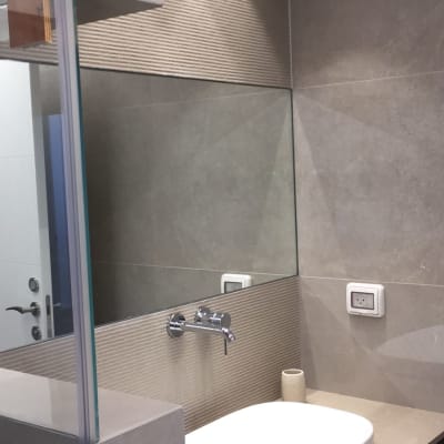 מראה גדולה על קיר חדר אמבטיה