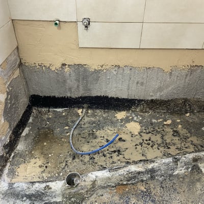 קיר חשוף עם צינור כחול, שיפוץ קיר ורצפה