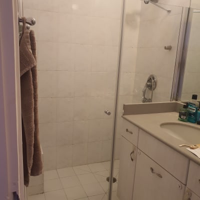 מקלחת עם דלת זכוכית ומגבות תלויות