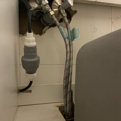 צינורות מים מחוברים לברזים בקיר עם חיבורים מתכתיים