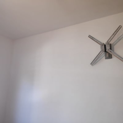 קיר צבוע בלבן עם מתקן מתכת מחובר