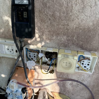 שקעים חשמליים פתוחים עם חוטים חשופים על קיר