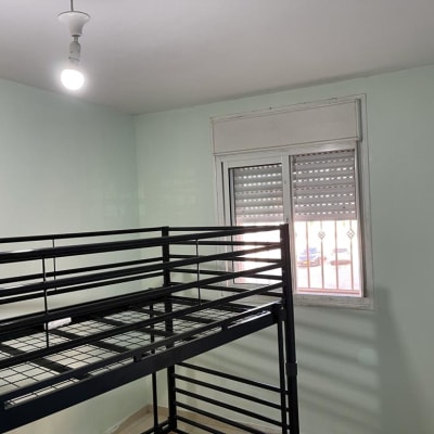 קיר צבוע בצבע ירוק בהיר עם מיטת קומותיים