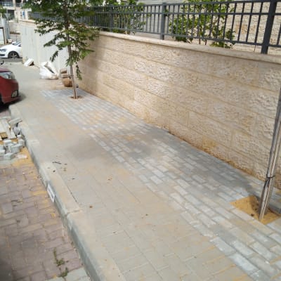 אבנים משתלבות מונחות על מדרכה בתהליך שיפוץ