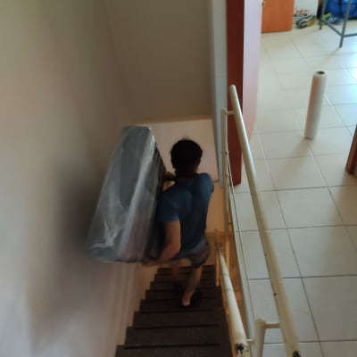 אדם נושא חפץ גדול עטוף בירידה במדרגות