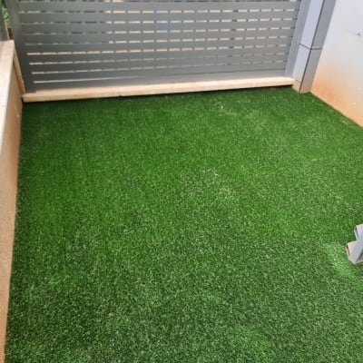 דשא סינתטי על רצפה מוקפת גדרות מתכת