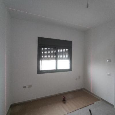 חדר עם קירות לבנים, נייר חום על הרצפה