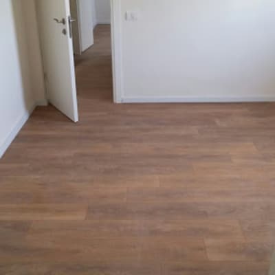 רצפת פרקט עץ בחדר ריק עם דלת פתוחה