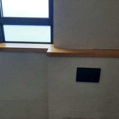 מדף עץ מותקן מתחת לחלון