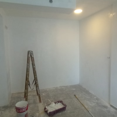 סולם, דלי צבע ומגש עם רולר בחדר בשיפוץ