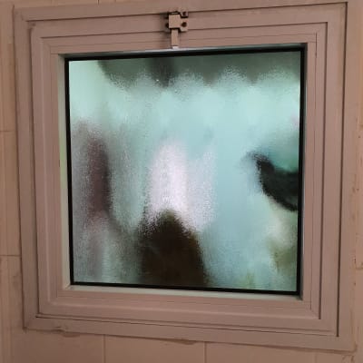 חלון זכוכית מט עם מסגרת לבנה