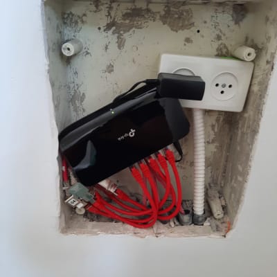 נתב עם כבלים אדומים מחוברים לשקע חשמל בקיר