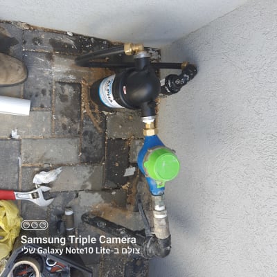מסנן מים וצנרת עם כלי עבודה על הרצפה
