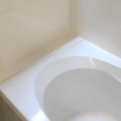 אמבטיה לבנה ליד חלון עם מסגרת שחורה