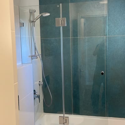 מקלחת עם דלת זכוכית, ראש מקלחת וכפתורי שליטה