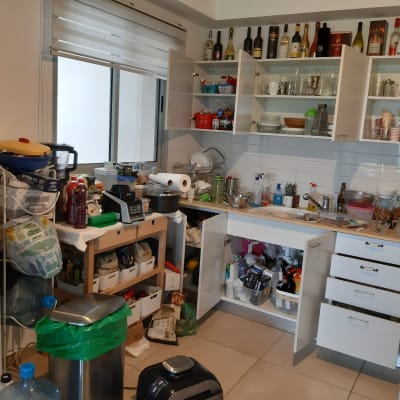 מטבח מבולגן עם ארונות פתוחים ומוצרי מזון