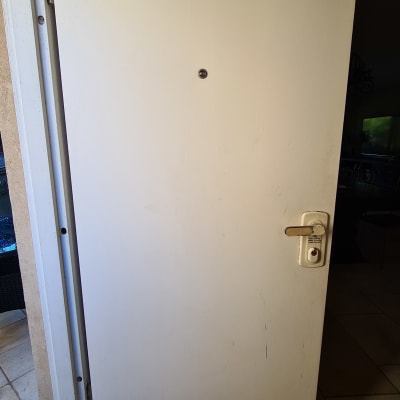 דלת עם קילוף צבע בתחתית וידית מתכת