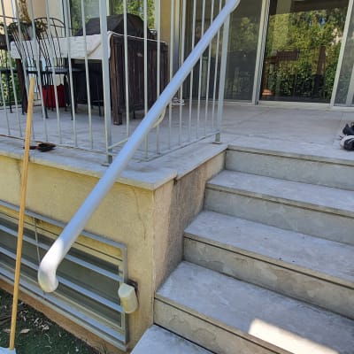 מעקה מתכת לבן על מדרגות חיצוניות