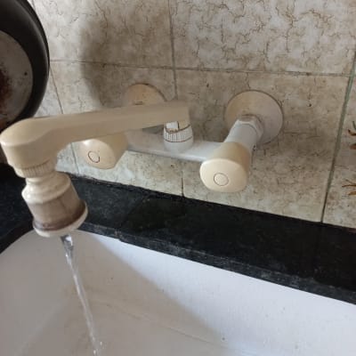 ברז מים זורם מעל כיור מטבח לבן