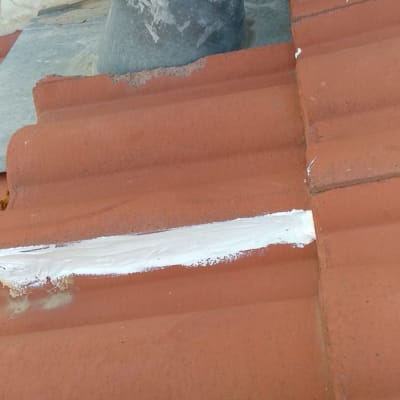 צינור מתכת על גג רעפים עם איטום לבן