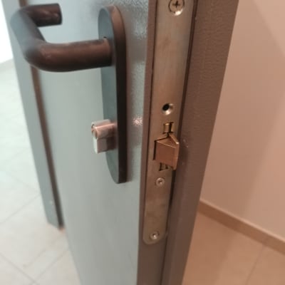 מנעול דלת מתכת עם ידית שחורה ובריח פתוח