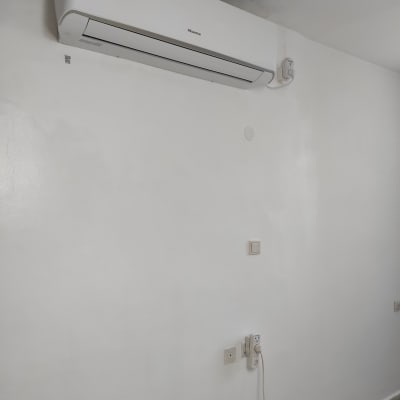 מזגן מותקן על קיר לבן עם שקע חשמל