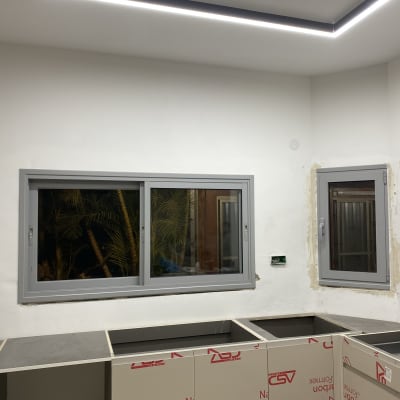 חלונות אלומיניום אפורים מותקנים בקיר לבן