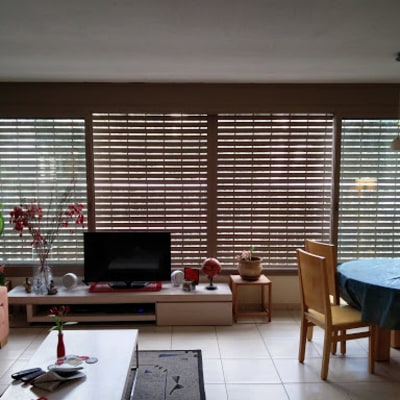 סלון עם תריסי אלומיניום על חלונות גדולים