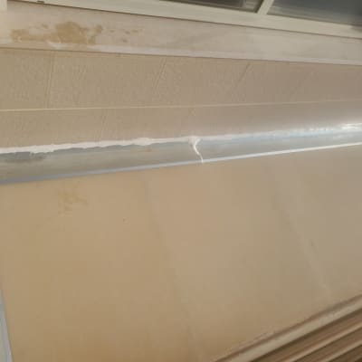 איטום עם חומר לבן על קיר וחלון