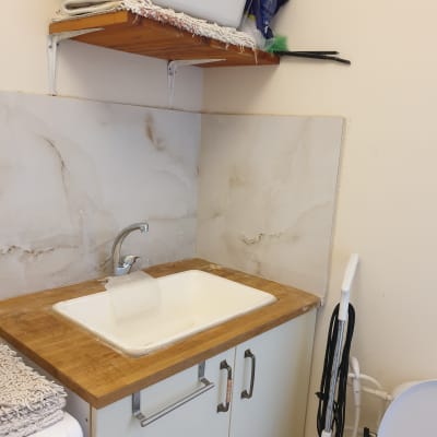 כיור עם ברז על משטח עץ, קיר מחופה קרמיקה