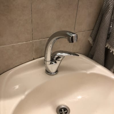 ברז כרום מותקן בכיור לבן בחדר אמבטיה