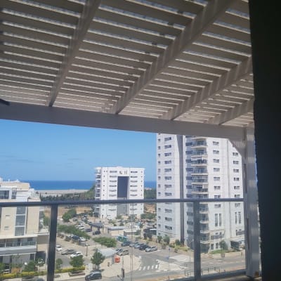 פרגולה מעץ על מרפסת עם נוף עירוני