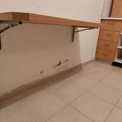 קיר עם סימני קילוף צבע ומדף עץ תלוי