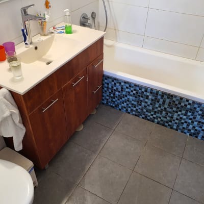 כיור אמבטיה עם ברז, ארון ומגבת תלויה