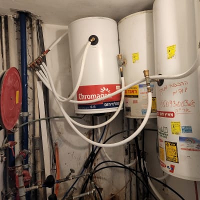 דודי שמש מותקנים עם צינורות חיבור ומדבקות אזהרה