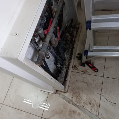 צינורות מים עם ברזים אדומים, כלי עבודה על הרצפה