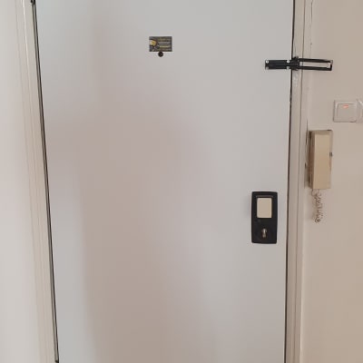 דלת לבנה עם מנעול ובריח עליון