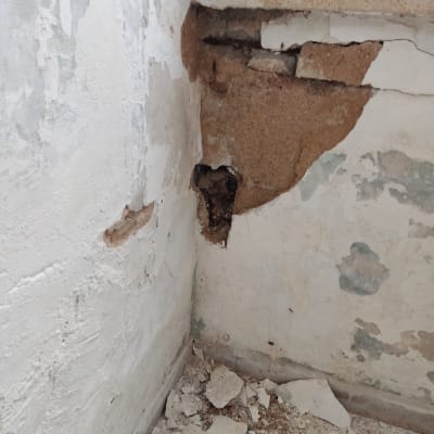 קיר מתקלף עם טיח מתפורר ופגמים בצבע