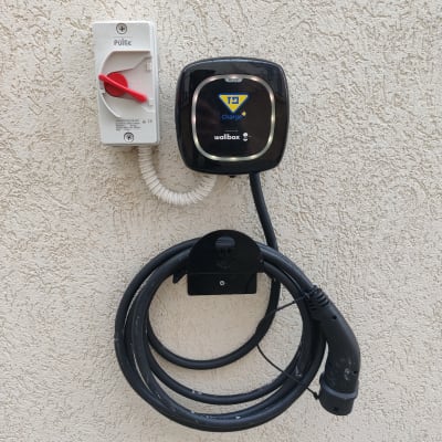 מטען חשמלי לרכב עם כבל תלוי על קיר