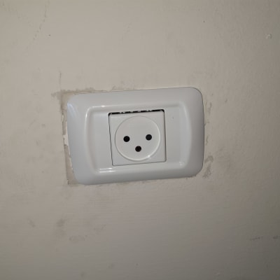 שקע חשמל בקיר עם מסגרת לבנה