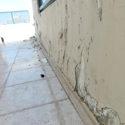 קיר עם צבע מתקלף וכתמים כהים