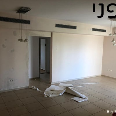 חדר ריק עם ניירות על הרצפה ותאורה תלויה