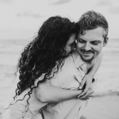 צילום שחור לבן של זוג מחובק על חוף הים