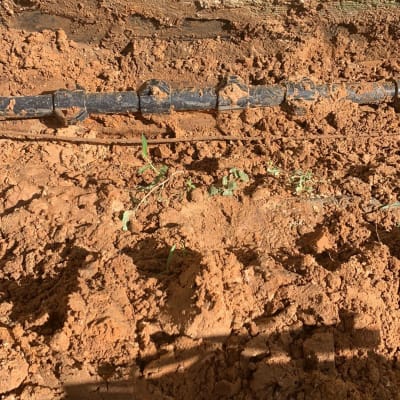 צינור שחור מונח באדמה חפורה