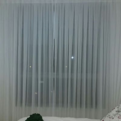 וילון לבן שקוף תלוי על חלון גדול