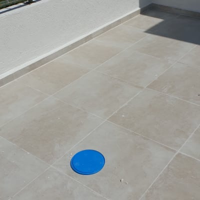 מכסה כחול על רצפת מרפסת מרוצפת