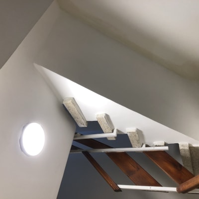 קיר צבוע בלבן עם מדרגות עץ ומתכת