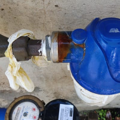 מד מים כחול עם חיבורים וצינור