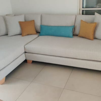 ספה אפורה עם כריות צבעוניות על רצפת אריחים.