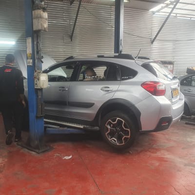 רכב על ליפט במוסך עם מכונאים